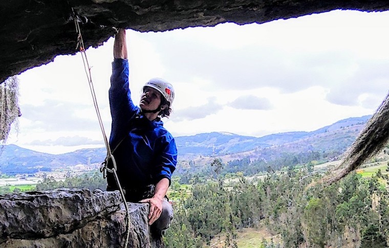 A climber outside a cave